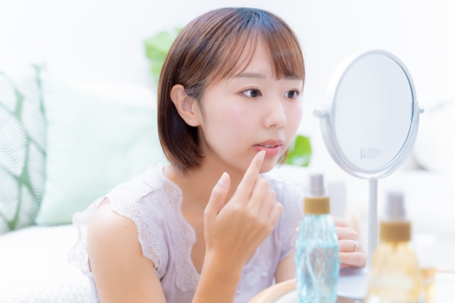鏡で口元を確認する女性