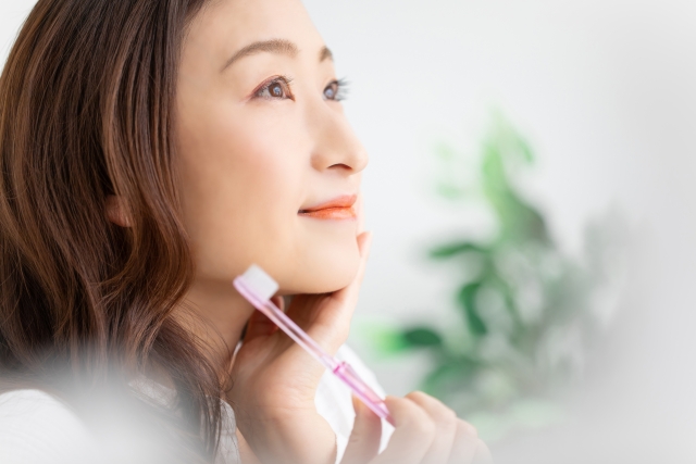 歯ブラシを持って微笑む女性