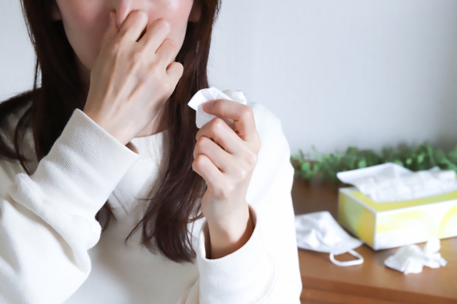 鼻をつまむ女性