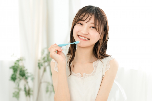 歯ブラシを持って微笑む女性