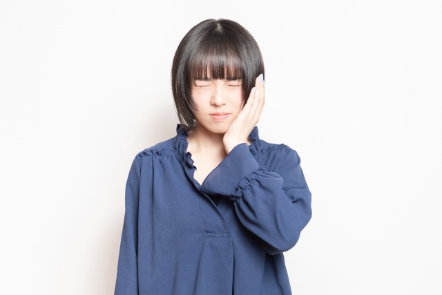 頬を押さえる女性