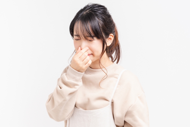 鼻を抑える女性