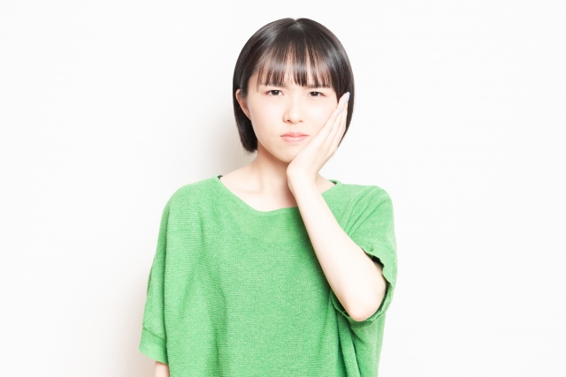 頬を押さえる女性