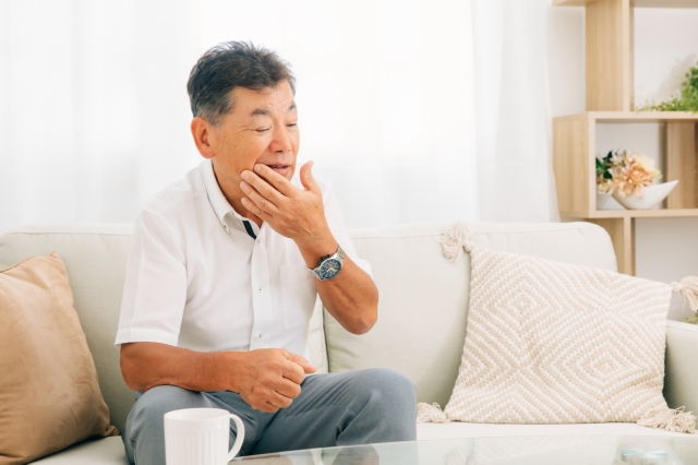 口元を押さえる男性