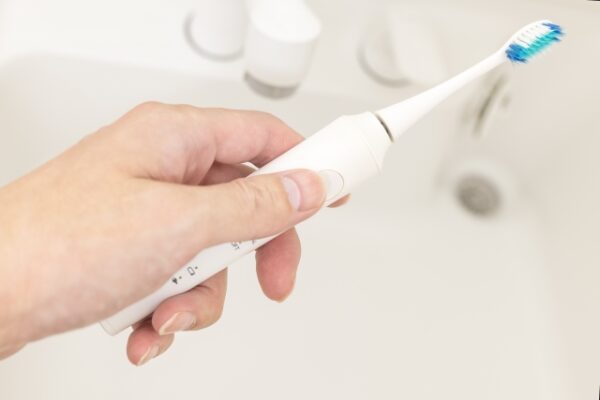 電動歯ブラシを使う手元