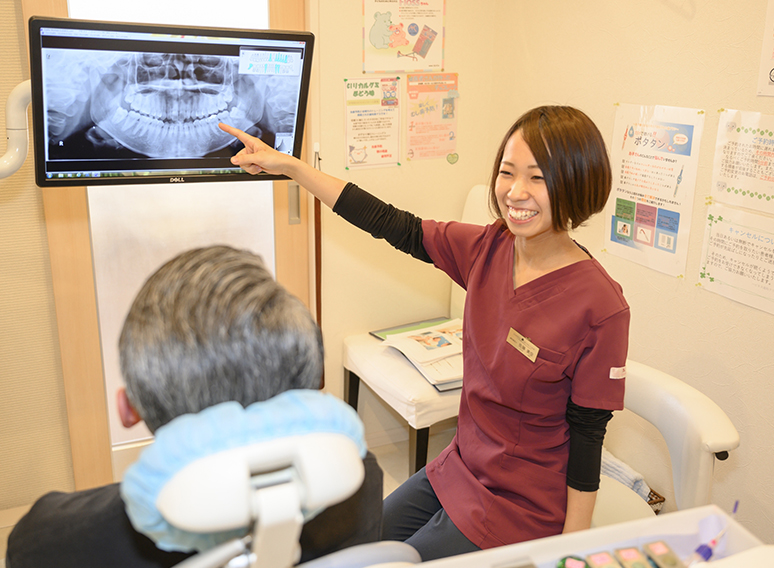 歯科衛生士が患者さまへレントゲン写真の説明をしている様子